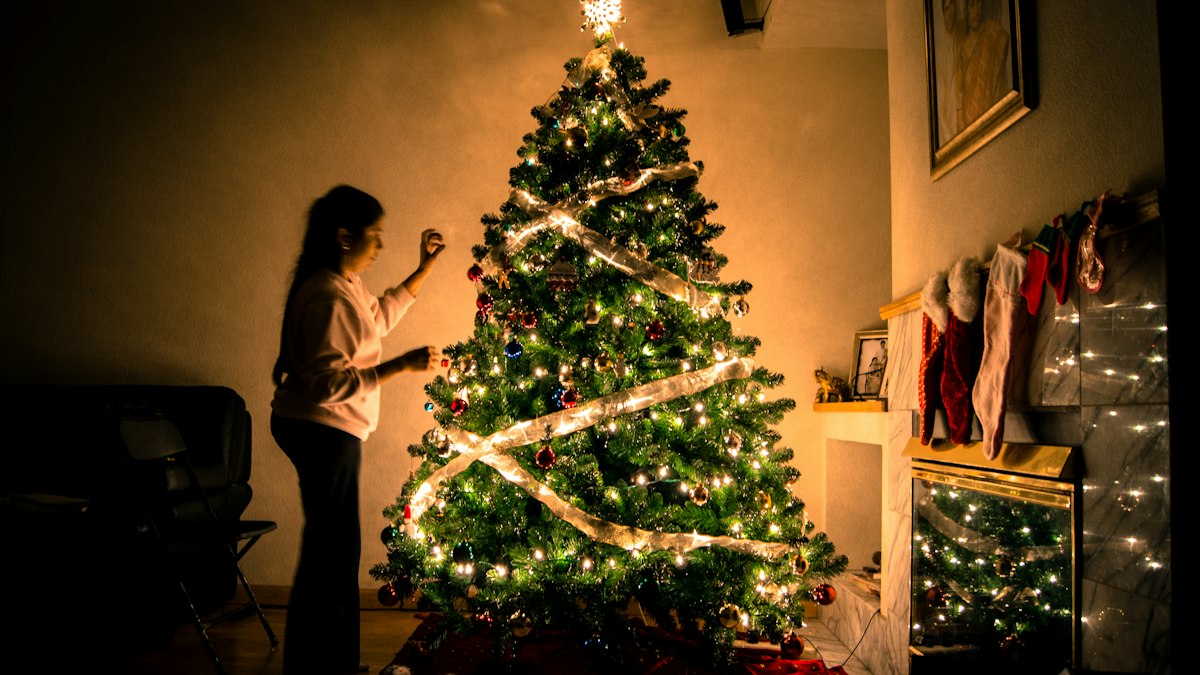 Niña frente a un árbol de Navidad iluminado